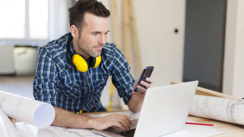 Contemporary construction worker with electronic equipment