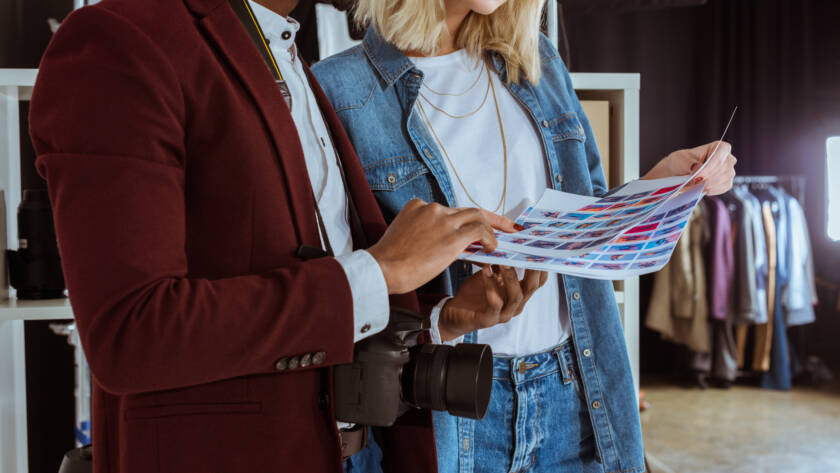 cropped shot of multiethnic photographers looking at portfolio together in studio